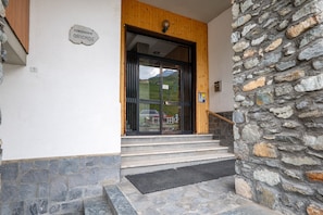 A stone wall, a wooden door, and a sign reading 'CONDOMINIO ORIONDE'.