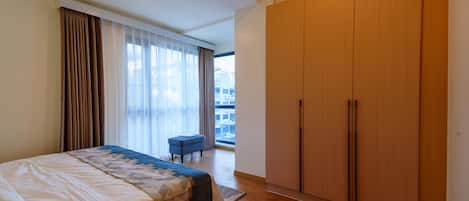 Une chambre d’hôtel avec un lit, une grande armoire et une vue sur la ville.