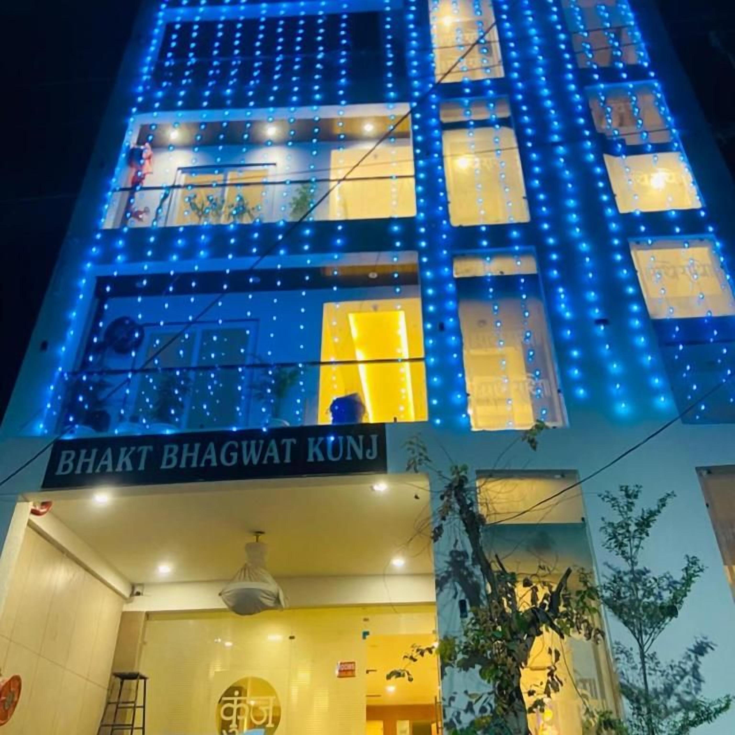 A building with a sign reading 'BHAKT BHAGWAT KUNJ' and a series of illuminated windows.