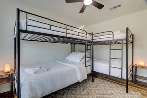 Quarto com beliche, ventilador de teto, aquecedor e tapete.