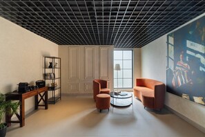 Un interior moderno con techo de diseño en cuadrícula, un ventanal grande y un cuadro en la pared.