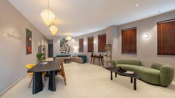 A modern living room with a dining area, featuring a sofa, a coffee table, and a dining table with chairs.