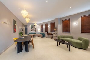 A modern living room with a dining area, featuring a sofa, a coffee table, and a dining table with chairs. - Minimalist - South Delhi (New Delhi)