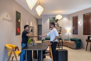 Un interior moderno con una zona de comedor, un conjunto de sofás y obras de arte en las paredes.