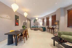 A modern living room with a dining area, featuring a sofa, a coffee table, and a dining table with chairs. - Minimalist - South Delhi (New Delhi)