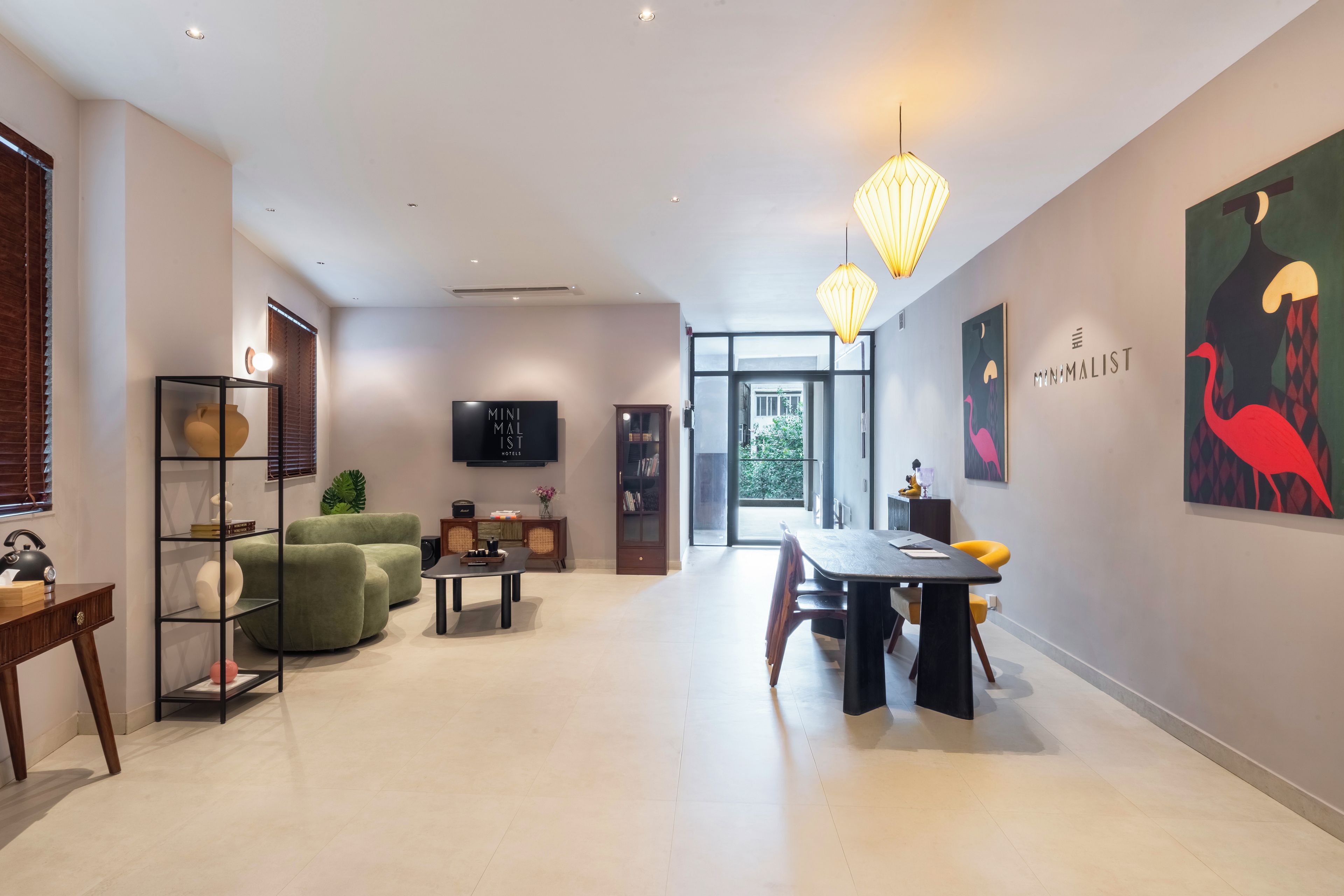 Een moderne hotellobby met een bank, eettafel en kunstwerken aan de wanden.