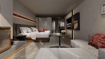 Una habitación de hotel moderna con cama, zona de estar, una mesita y televisor montado en la pared.