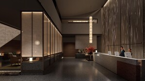 Uma área de recepção moderna com balcão, espaço para sentar e escada.