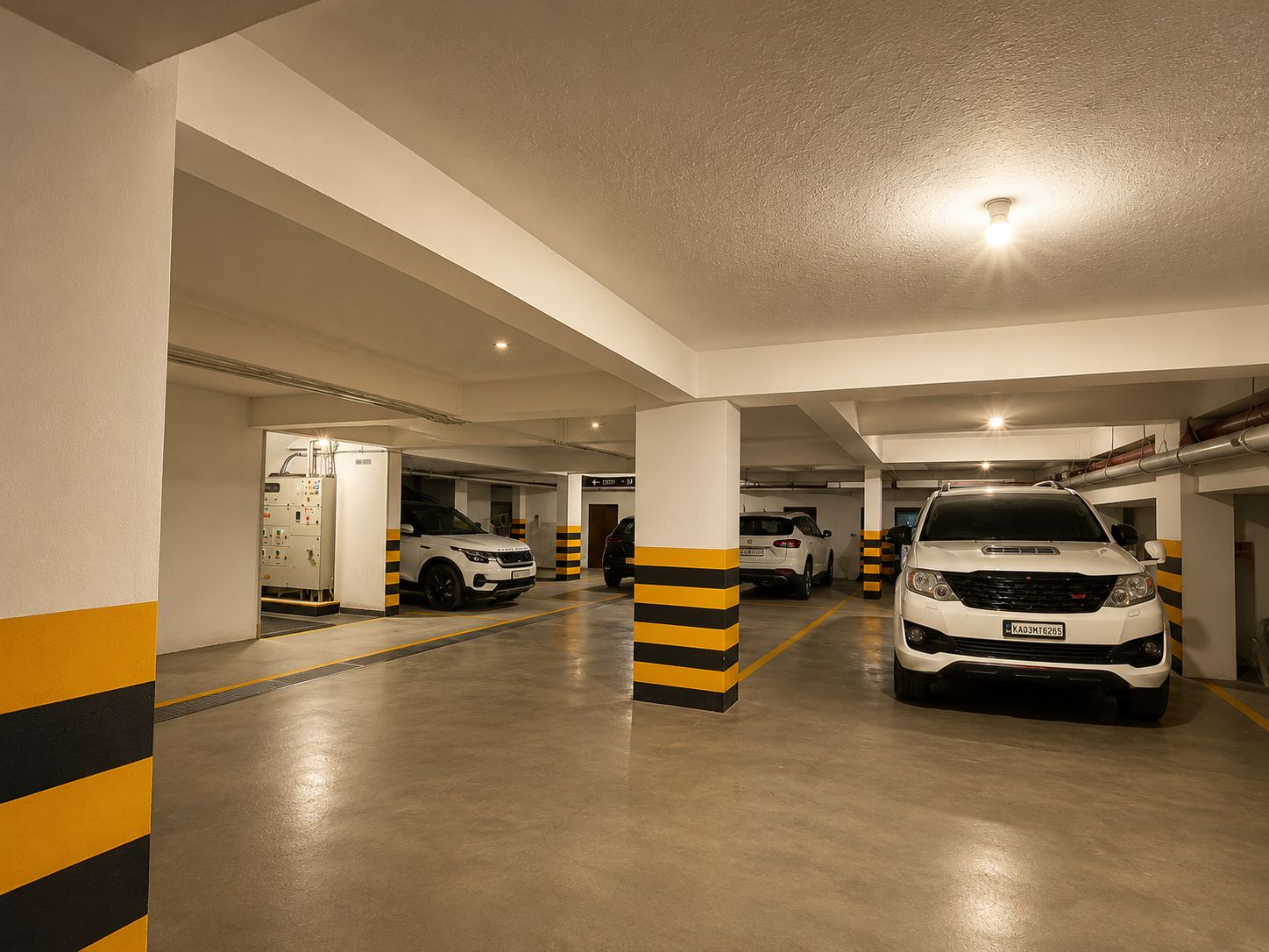 A multi-level parking garage with white and yellow striped pillars, a white car in the foreground, and a white SUV in the background.