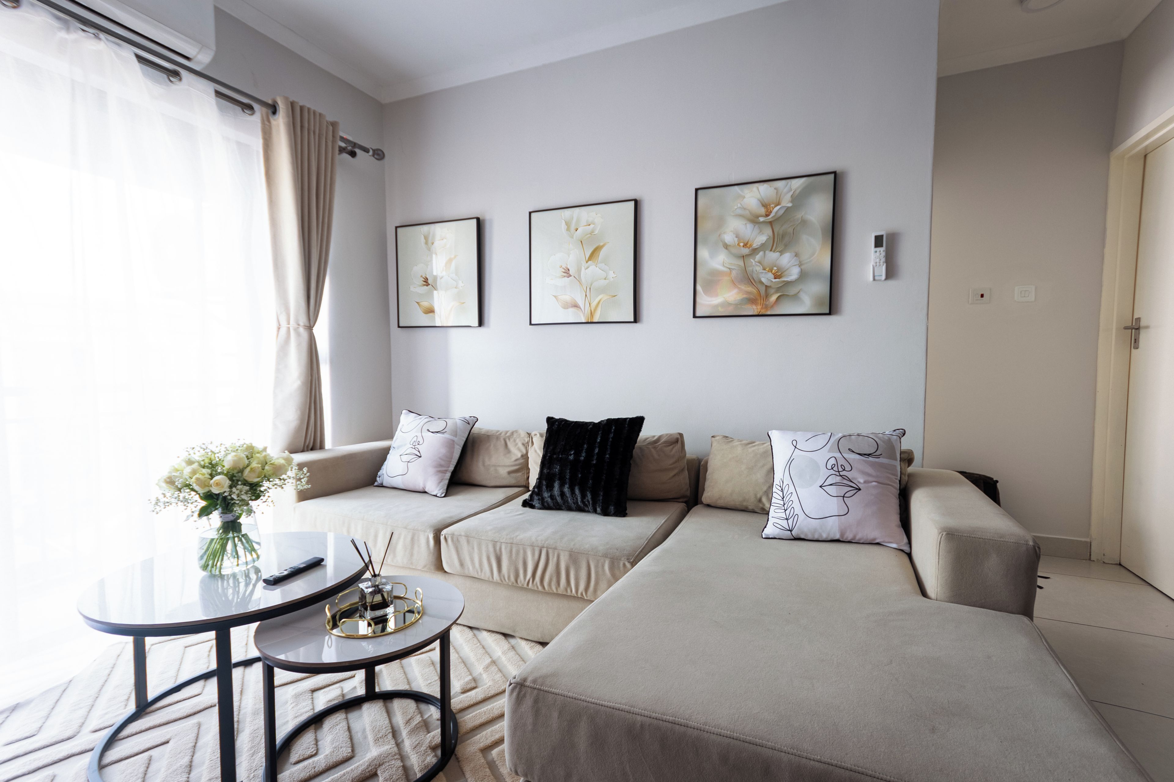 A modern living room with a sofa set, a coffee table, and wall art.
