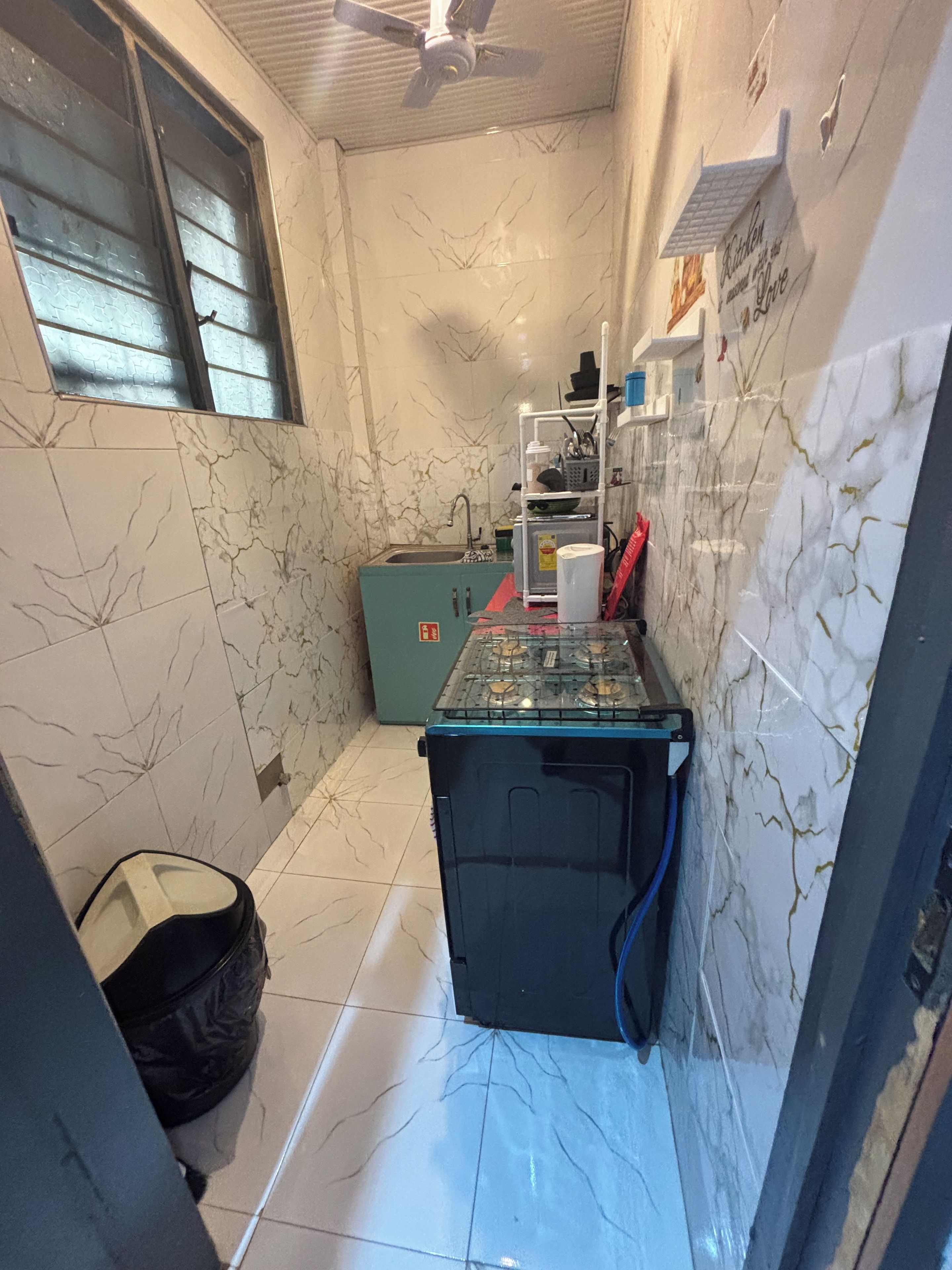 A compact kitchen with a refrigerator, a sink, and a window.