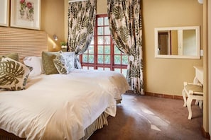 A bedroom with a large bed, a window with curtains, a bedside table, and a mirror. - Magalies Park Resort 2-bedroom WBT Rentals (Hartbeespoort)