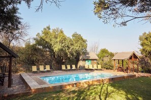 A swimming pool with lounge chairs, a gazebo, and a covered seating area. - Magalies Park Resort 2-bedroom WBT Rentals (Hartbeespoort)