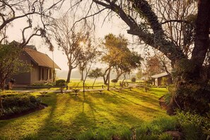 A serene landscape with a house, a fence, and a grassy area. - Magalies Park Resort 2-bedroom WBT Rentals (Hartbeespoort)