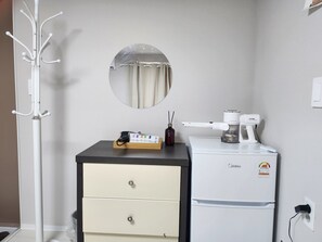 A compact kitchenette with a refrigerator, a coffee maker, and a small cabinet. - Maison Veluna (Seoul)