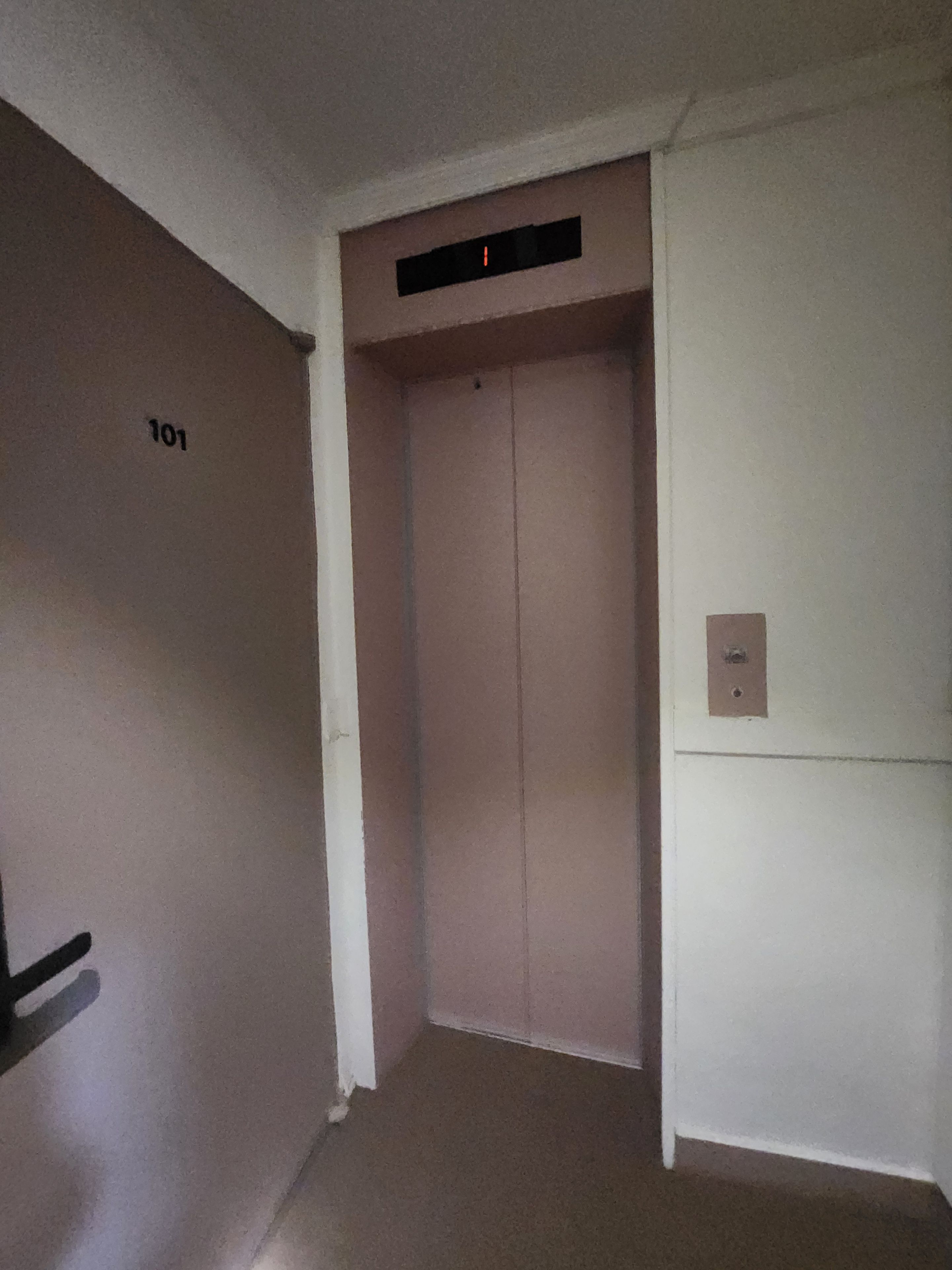 A hallway with a door labeled '101' and an elevator.