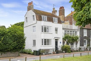 A two-story white building with multiple windows, a visible entrance, and a small porch area. - 3BDR Historic Burne Jones Cottage in Rottingdean (Brighton and Hove)