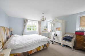 A bedroom with a bed, a dresser, a mirror, a chair, and a window. - 3BDR Historic Burne Jones Cottage in Rottingdean (Brighton and Hove)