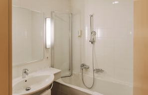 A bathroom with a sink, mirror, and shower. - HeinHotel Familienapartment XL (Schwechat)