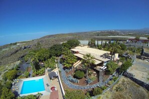 Un complexe hôtelier doté d’une piscine, d’un patio couvert et offrant une vue sur le paysage environnant.