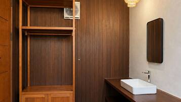 Un interior de madera con un banco empotrado, un lavabo blanco y una lámpara colgante.