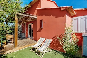 A red building with a wooden deck and two striped lounge chairs. - Villa Sylody: mountain view, Wi-Fi, air conditioning, near San Ciprianu beach (Lecci)