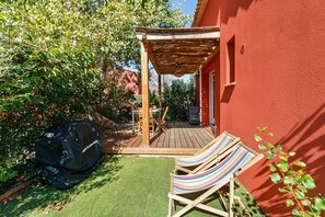 A wooden deck with a pergola, a barbecue grill, and two striped lounge chairs. - Villa Sylody: mountain view, Wi-Fi, air conditioning, near San Ciprianu beach (Lecci)