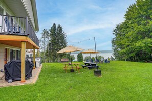 A backyard with a covered patio, picnic table, and outdoor seating area. - Lake Views, Hot Tub! Chautauqua Family Retreat (Mayville)