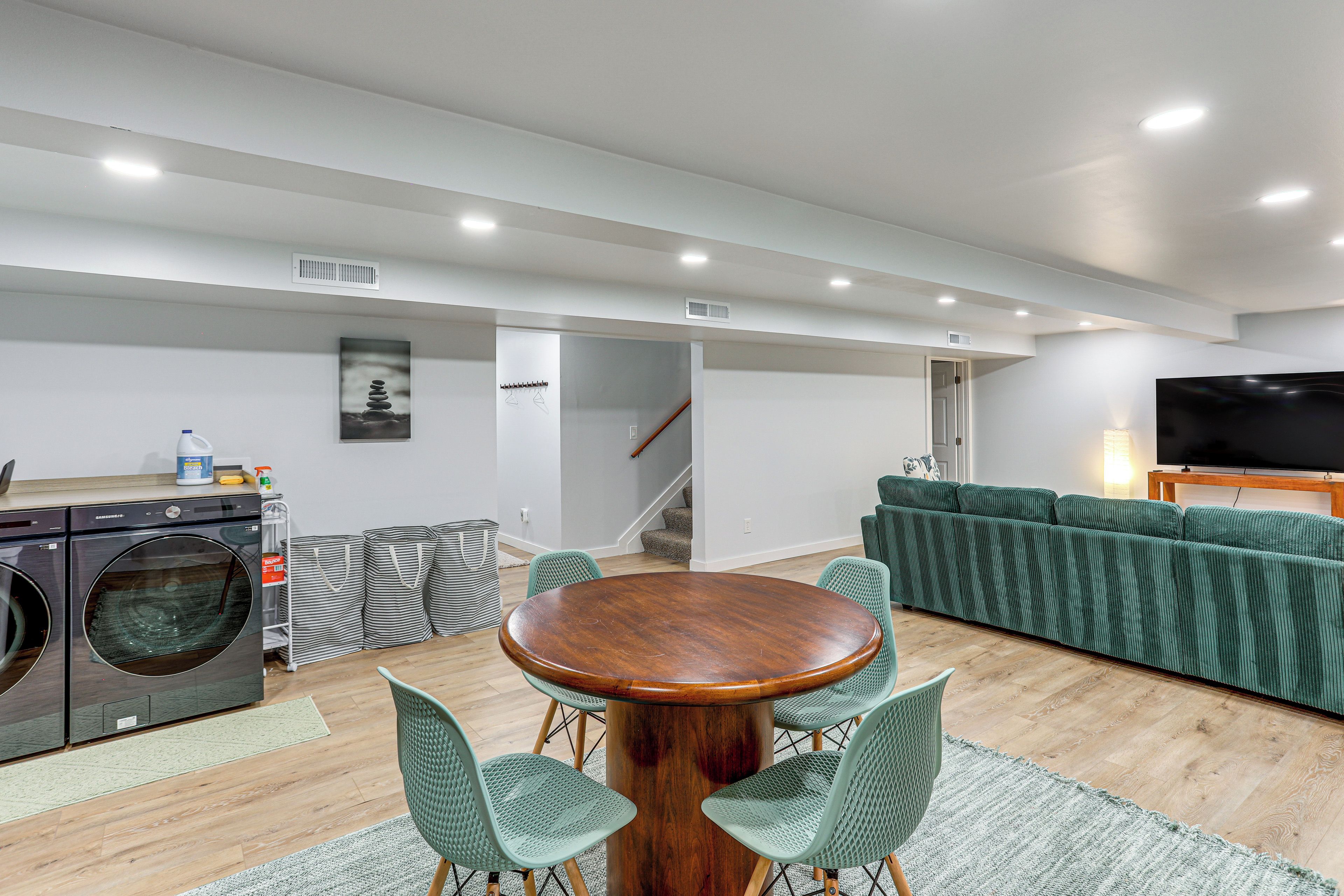 Een moderne woonkamer met een eethoek, een wasmachine en een televisie.