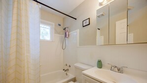 A bathroom with a bathtub, toilet, sink, and a shower head. - Walk to Prospect Lake! Quiet Home w/ Porch (Colorado Springs)