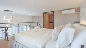 Een moderne slaapkamer met een groot bed, een bureau en een balkon.