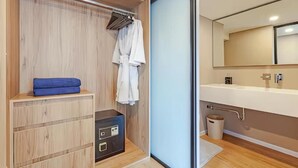 Een moderne badkamer met een houten wastafelmeubel, een spiegel en een handdoekhouder.