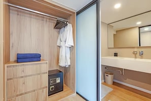 A modern bathroom with a wooden vanity, a mirror, and a towel rack. - Cassia Residence Rama 9 Bangkok (Krung Thep Maha Nakhon)