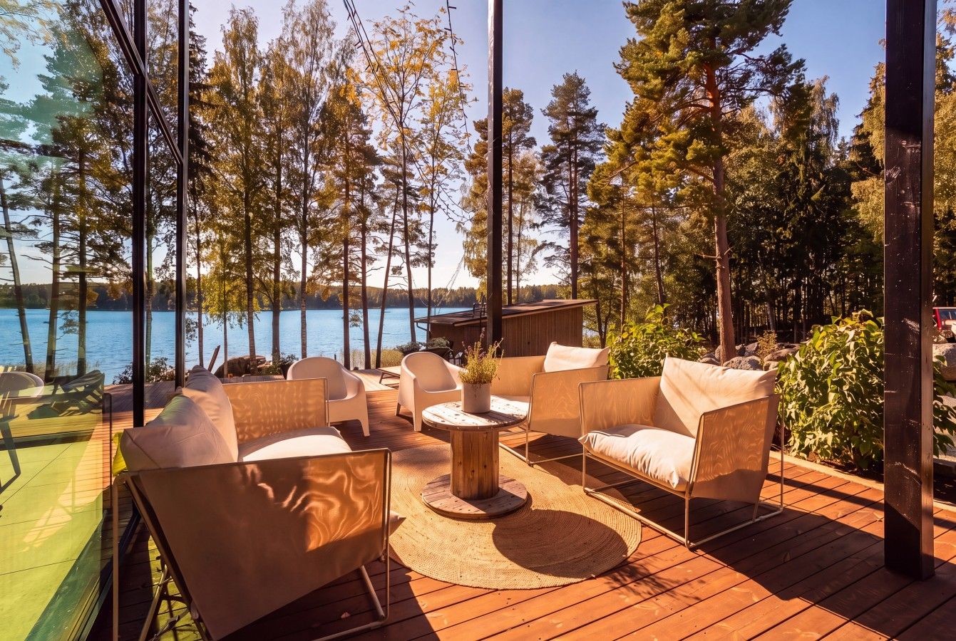 An outdoor deck with seating and a view of a lake.