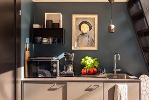 A kitchen with a microwave, coffee maker, and fresh produce on the counter. - Stay North - Vuohilahti (Valkeakoski)