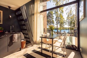 A modern kitchen with a large window, a dining area with a table and chairs, and a view of the outdoors. - Stay North - Vuohilahti (Valkeakoski)