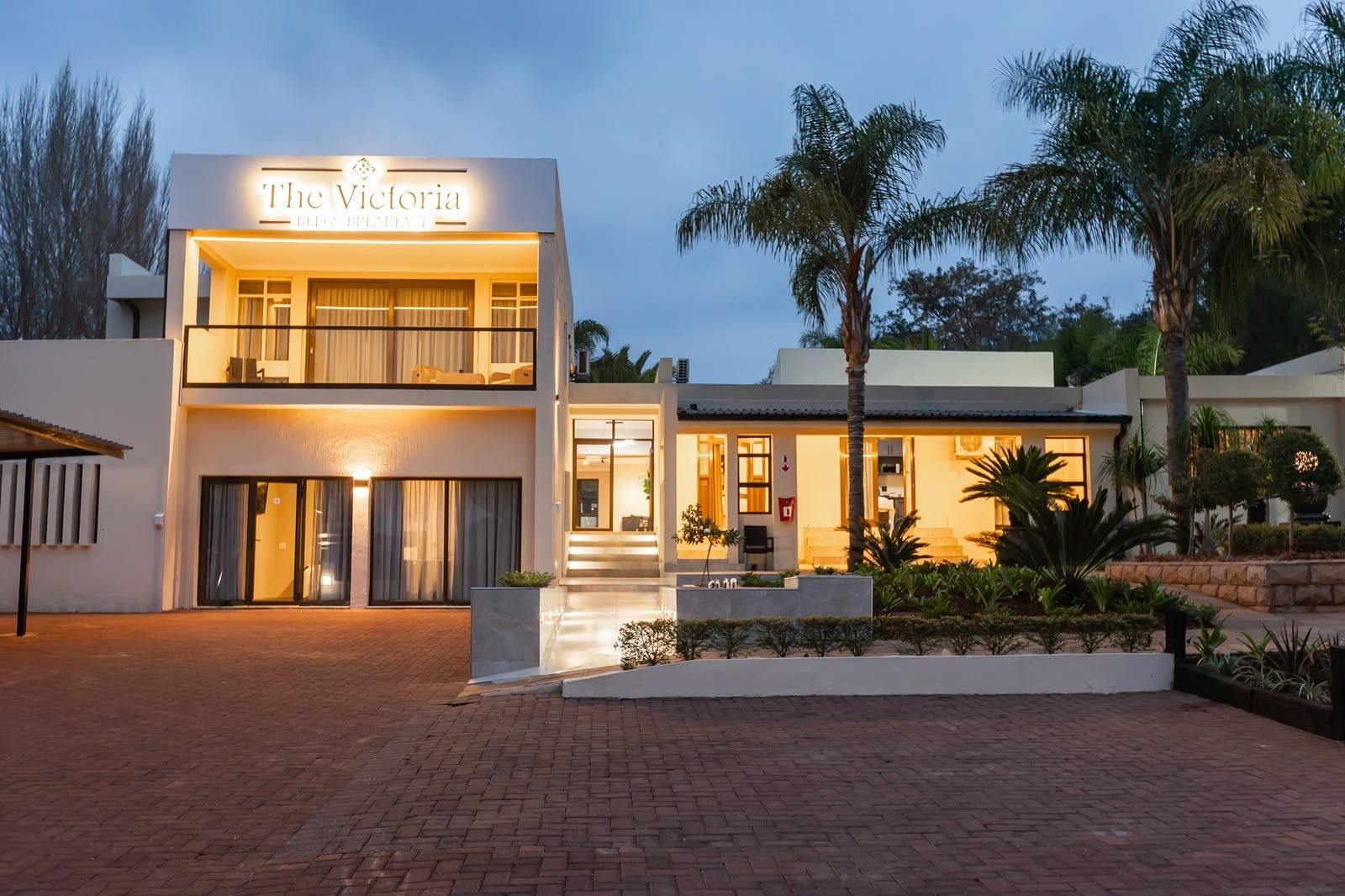 A modern two-story hotel with a sign reading 'The Victoria.'