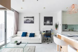 Ein modernes Wohnzimmer mit Sofa, Couchtisch und Kunstwerken an den Wänden.