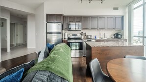 Una cocina moderna con electrodomésticos de acero inoxidable, una isla central y vistas de la ciudad.