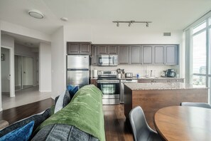 Una cocina moderna con electrodomésticos de acero inoxidable, una isla central y vistas de la ciudad.