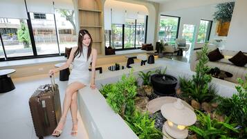 A modern interior with a seating area, a fountain, and a view of the outdoors.
