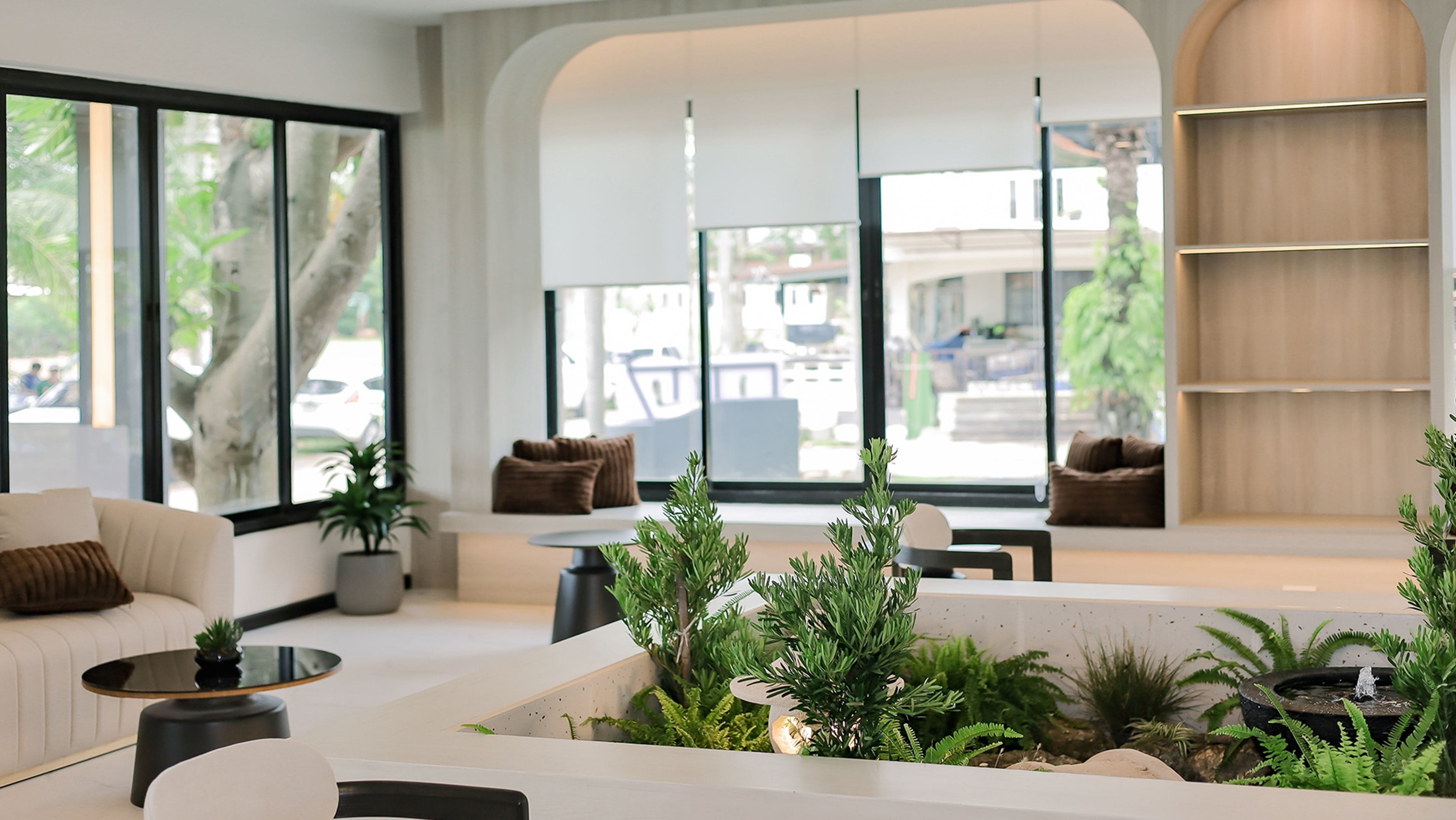 A modern living room with a sofa, a coffee table, and a plant arrangement.