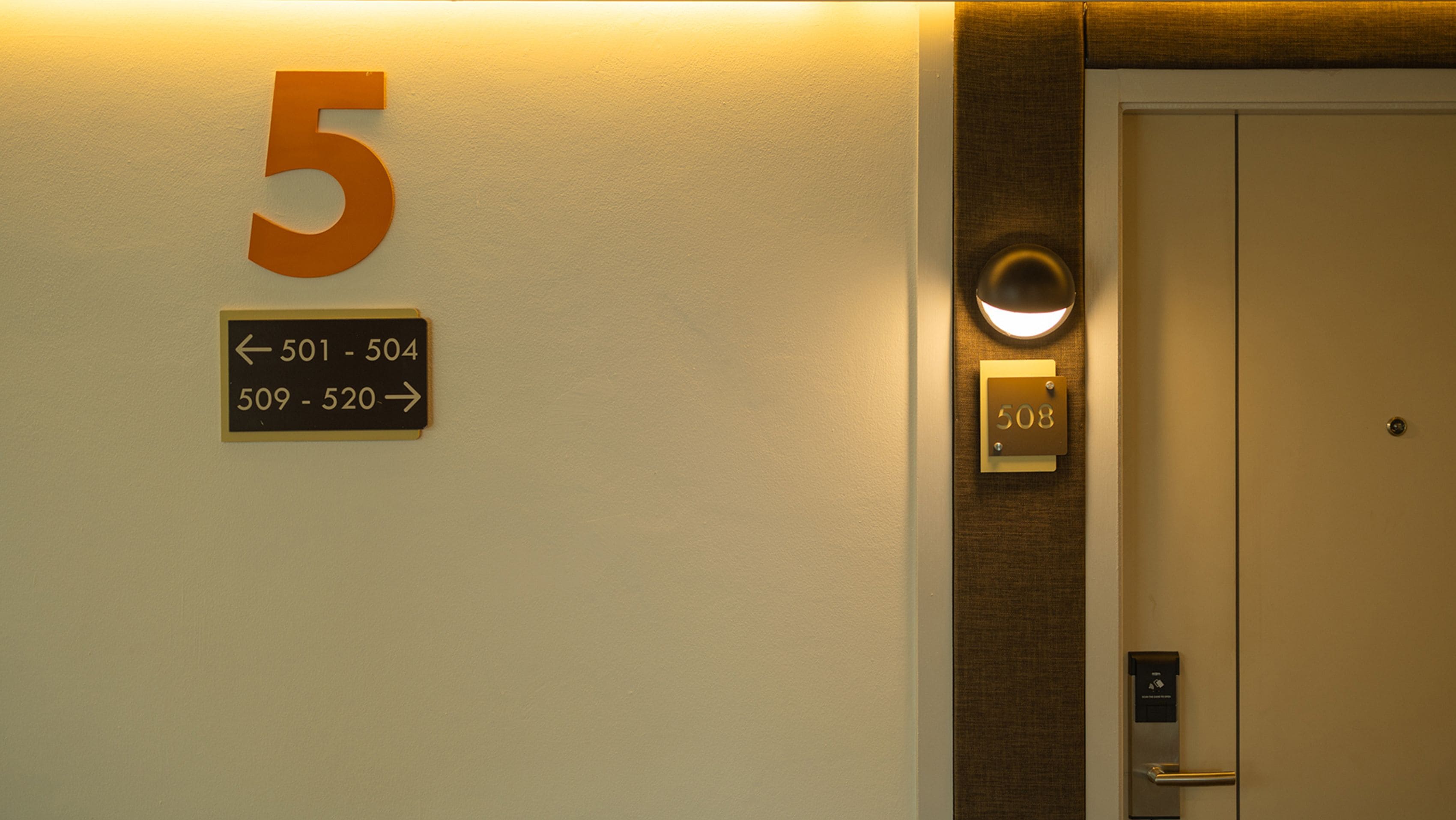 A wall with a large number '5' sign and directional arrows indicating room numbers 501-504 and 509-520.