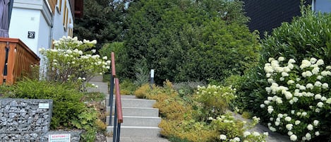 A residential building with a stone staircase leading to a wooden deck.