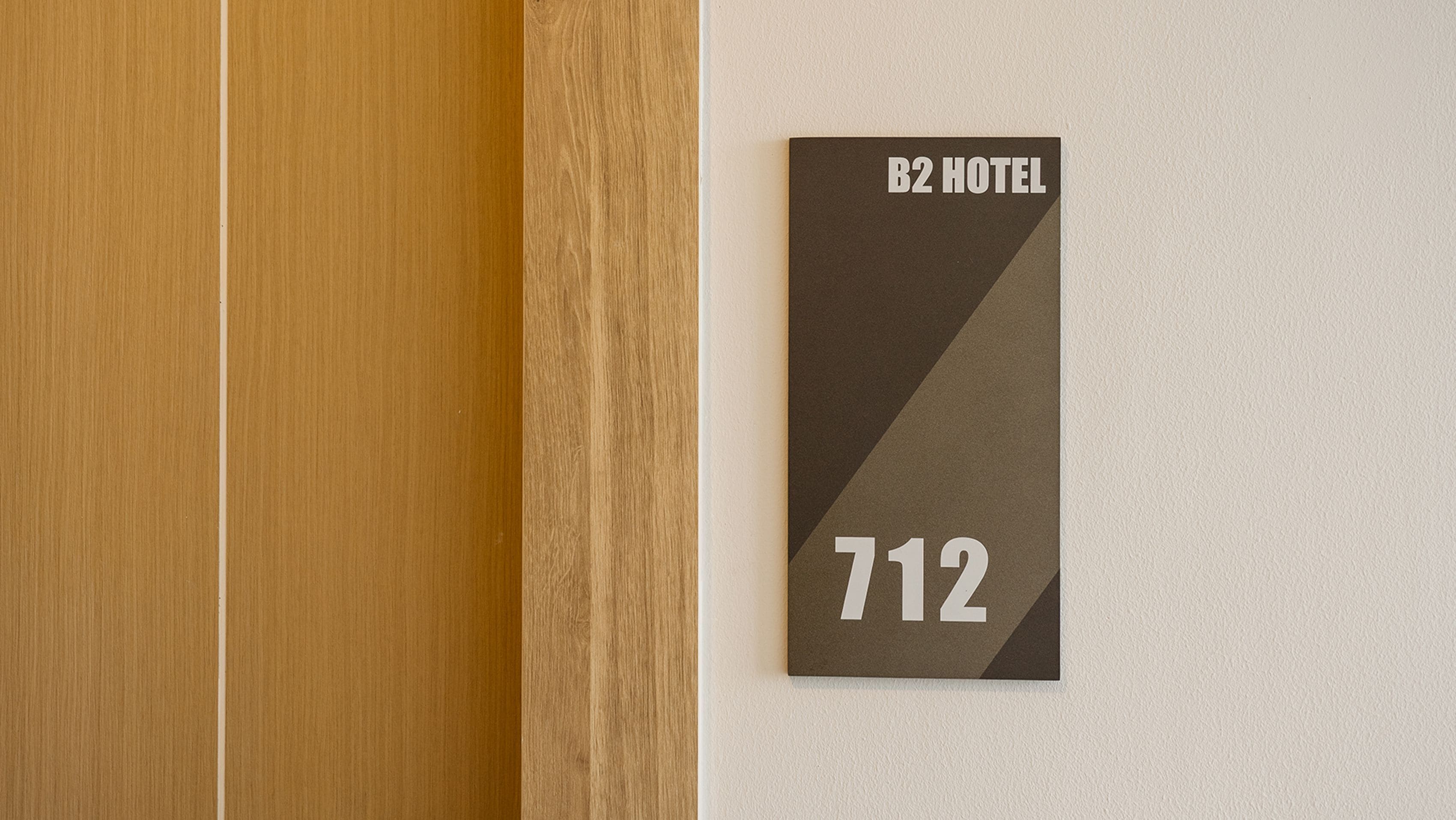 Schild mit der Zimmernummer einer Hotelzimmers, 'B2 HOTEL' und der Nummer '712'.