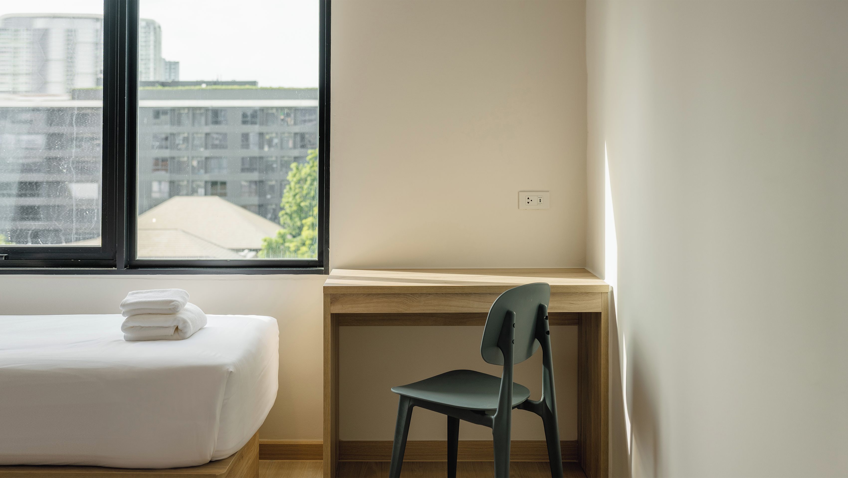 A room with a bed, a desk, and a chair.