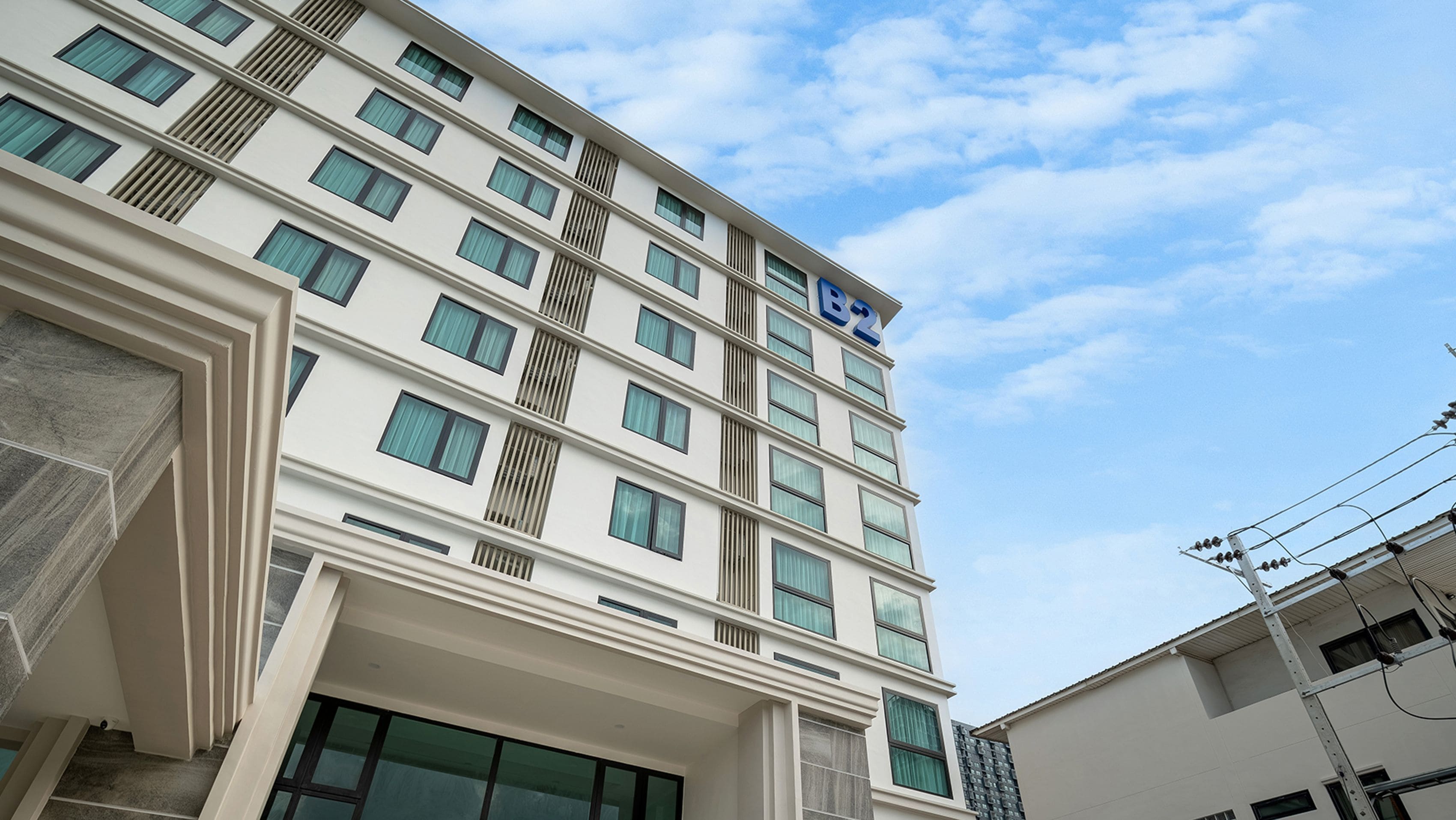 A multi-story hotel with a modern design, featuring a prominent 'B2' sign on the facade.