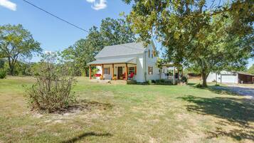 A single-story house with a porch, a garage, and a well-maintained lawn.