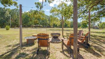 An outdoor seating area with wooden chairs and a fire pit.