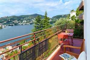 A balcony with a view of a lake and surrounding buildings. - Como in the Sky (Como)